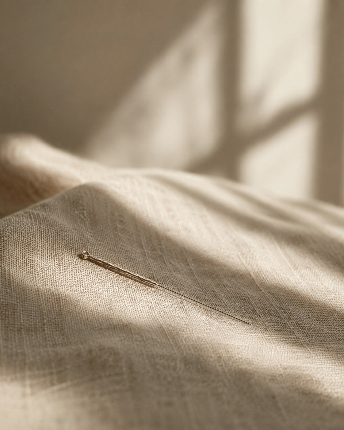 Aguja de acupuntura sobre lino, fotografía editorial